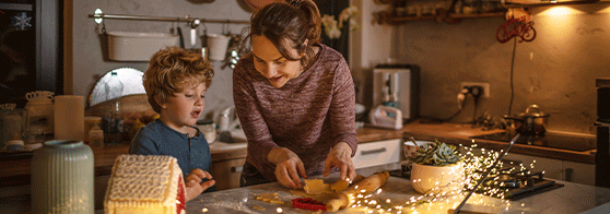 Femme dans une cuisine avec son fille faisant des biscuits de noël ensemble